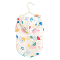 Small dog wearing a colourful cartoon umbrella pattern polyester raincoat.
