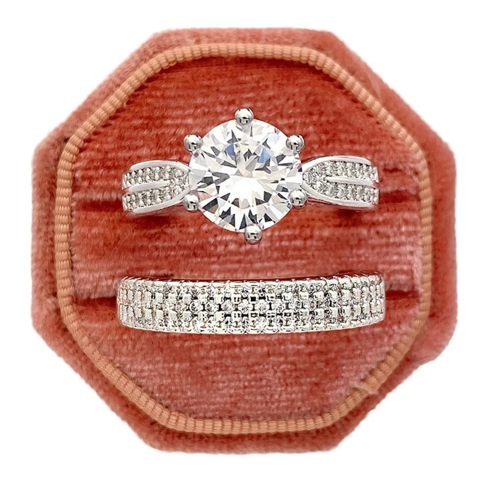 Geometric white gold colour alloy wedding ring bracelet with round detail on a finger.
