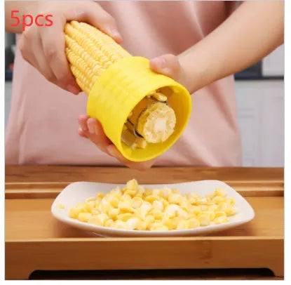 Yellow manual corn grinder thresher kitchen tool with corn-shaped design and stainless steel gear.