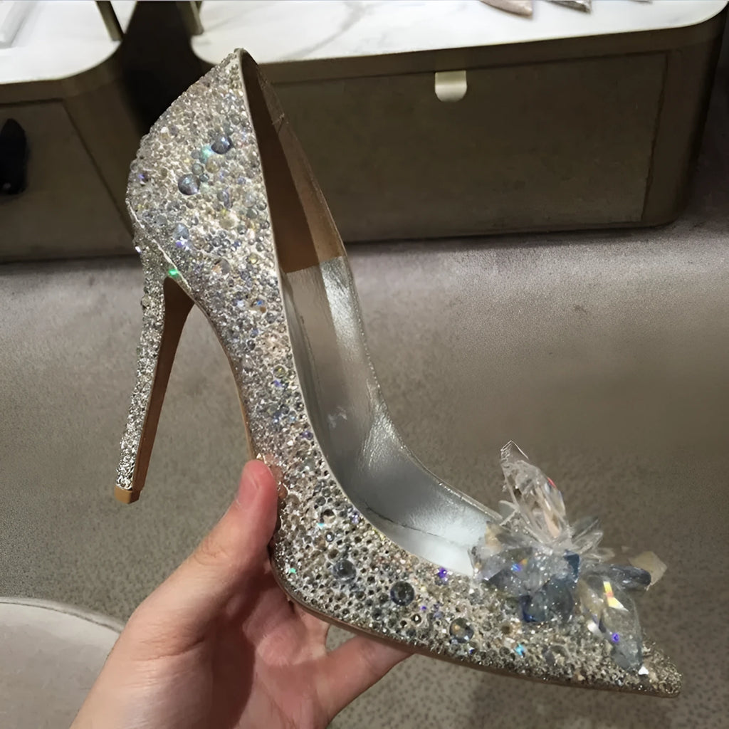 Gold women's pointed toe high heels with rhinestone and sequin decorations on a stiletto heel.