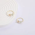 Geometric gold-colour women's ring with a triangular horse eye tricolour zircon stone.