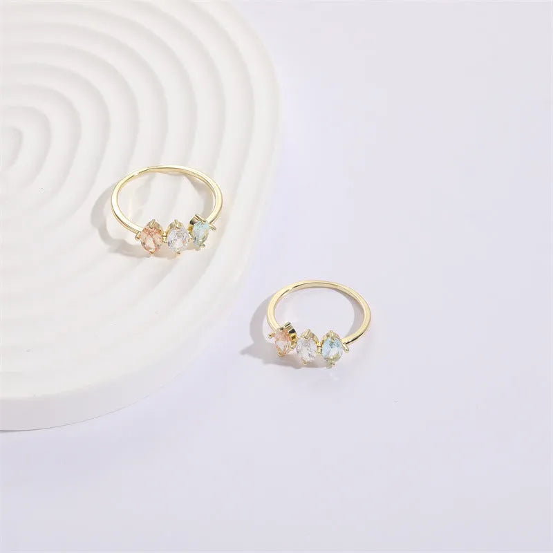 Geometric gold-colour women's ring with a triangular horse eye tricolour zircon stone.