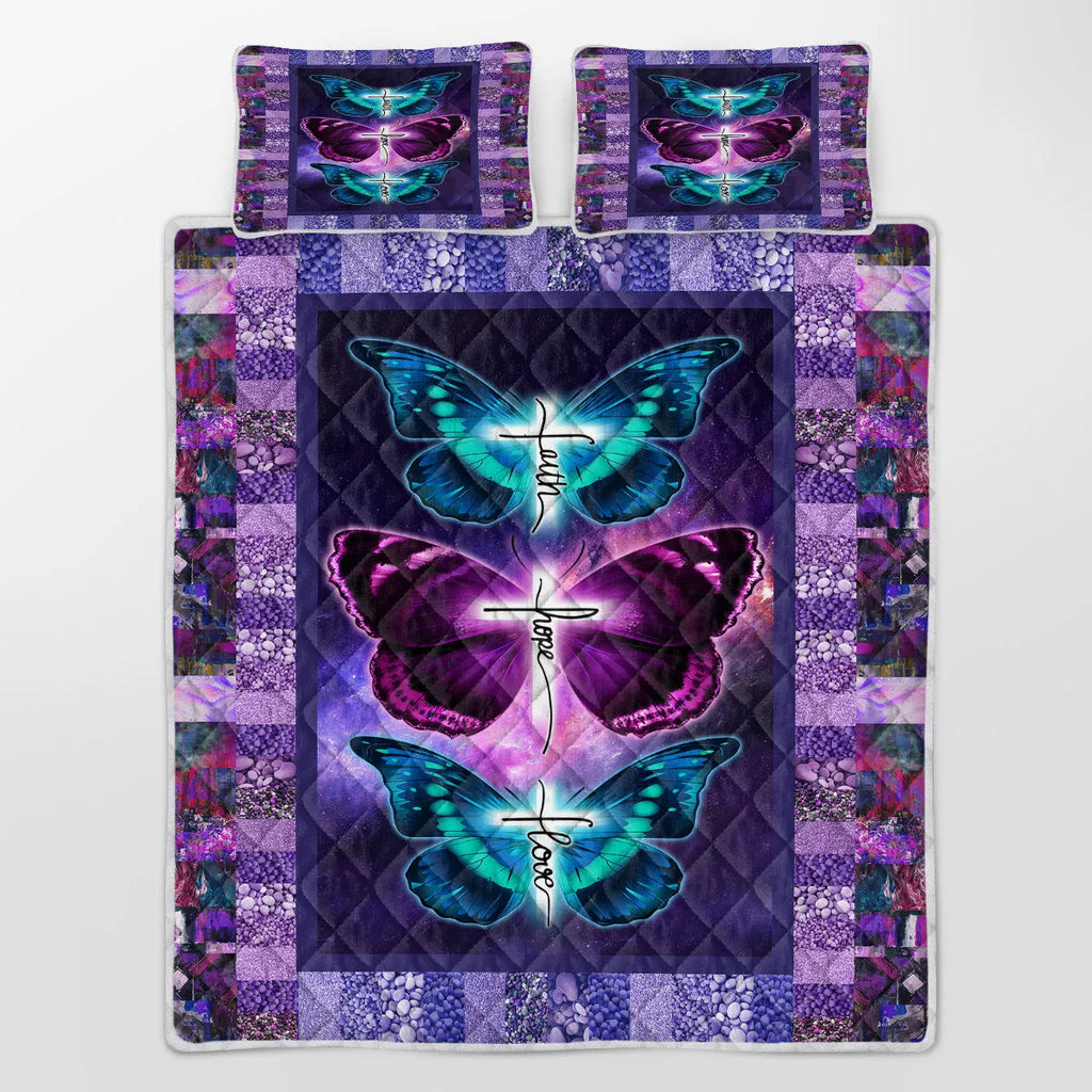 Purple 3-piece butterfly patterned quilt set with quilt and two pillow shams on a bed