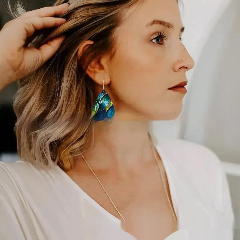 A pair of printed acrylic drop earrings with a flat branch knot design.
