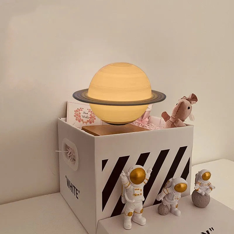 Moon planet floating LED night light with three astronaut figurines on dark surface