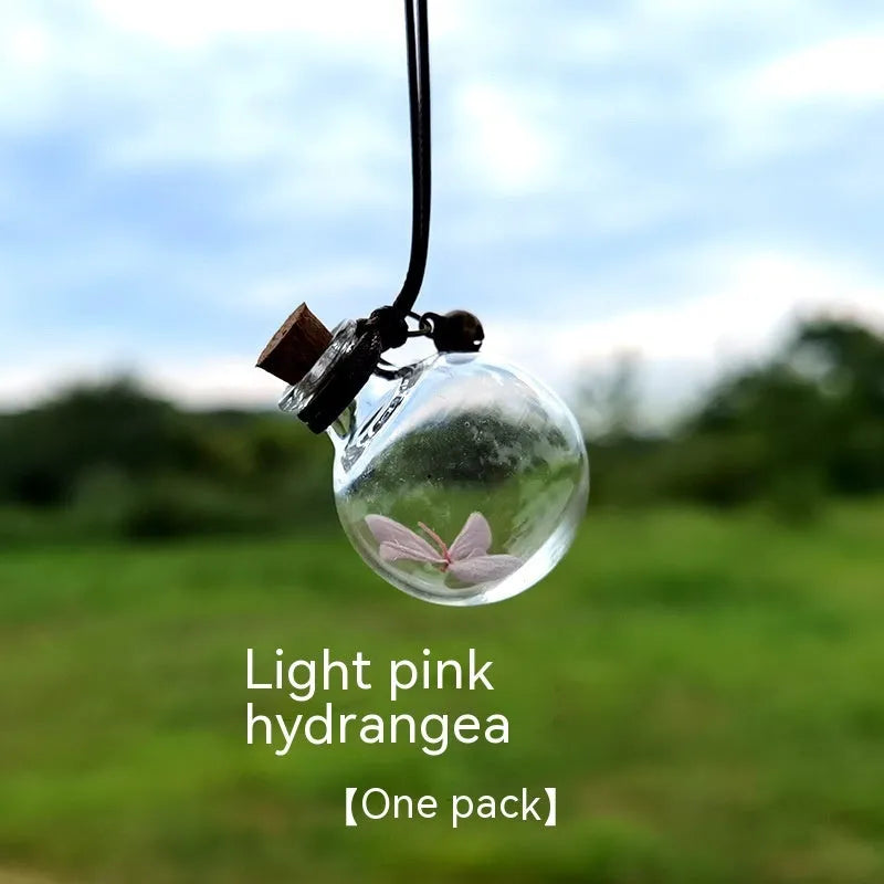 Glass car perfume pendant with preserved flower decoration hanging in car interior
