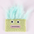 Colourful catnip plush toy with a funny big mouth explosion head shape on a blue background.