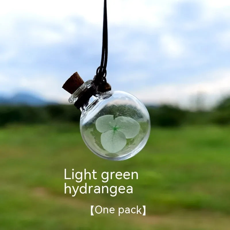 Glass car perfume pendant with preserved flower decoration hanging in car interior