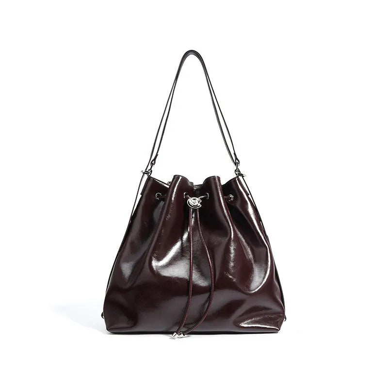 Genuine leather one shoulder bucket bag in brown showing retro style and interior pockets.