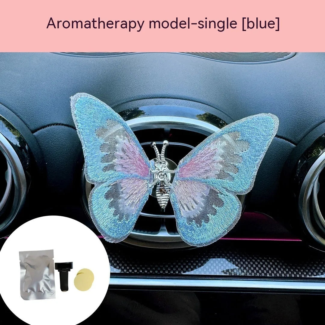 Fabric embroidered butterfly car air vent decoration in multiple colour options on a dashboard.