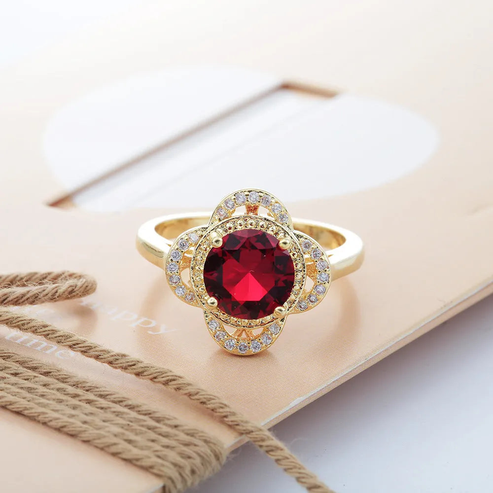 Copper fruit-shaped ring with zircon detailing on a neutral background.