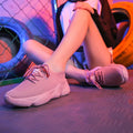 Women's white low-top woven sneakers with thick rubber sole and elastic front strap.