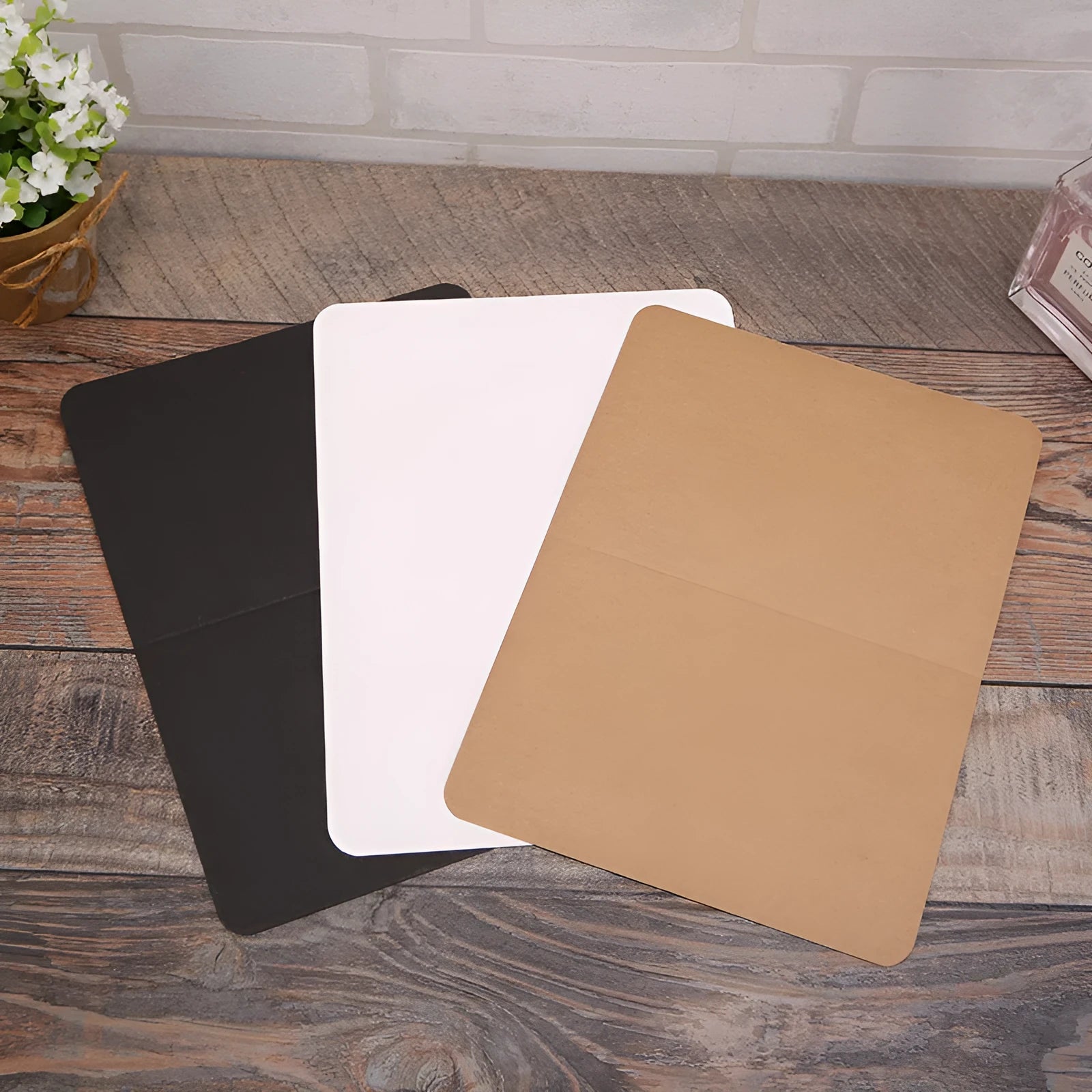 Pack of 100 blank folded kraft greeting cards in 10x15cm size, showing black, brown, and white colour options.