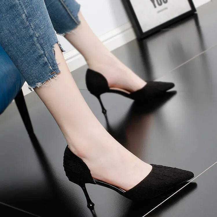 Women's black pointed high heel shoes with stiletto heel on light background