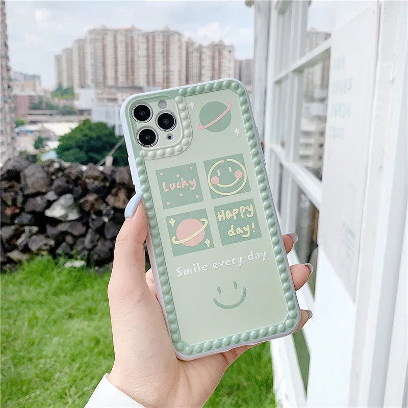 Green TPU iPhone back cover case with geometric smiley face and polka dot frame pattern.