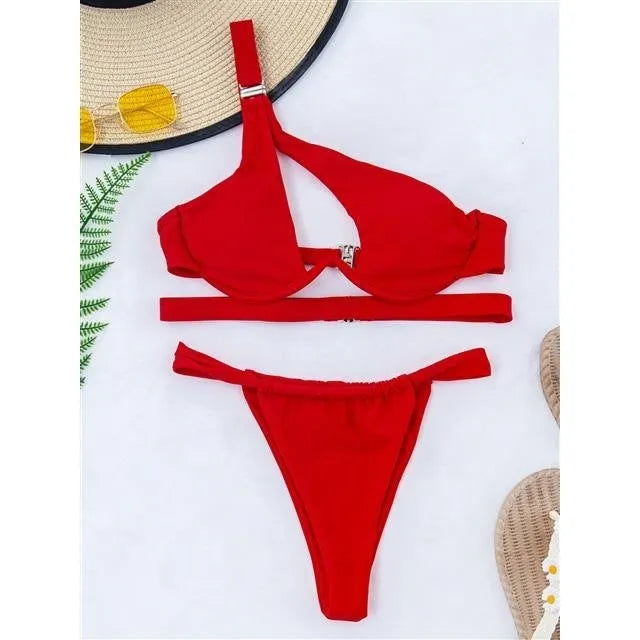 Women's solid colour split swimsuit with high-cut leg in red, front view, on beach setting