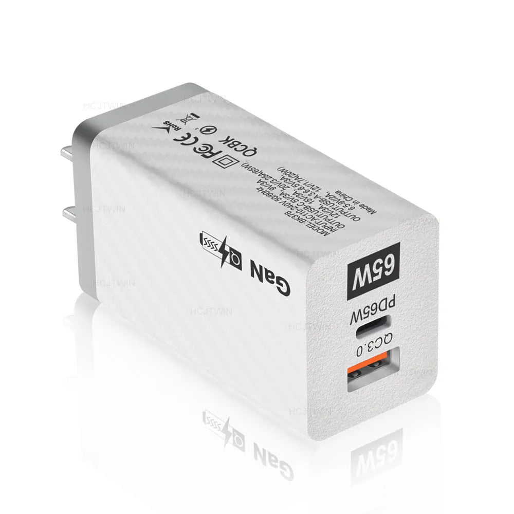 White 65W GaN fast charger with a foldable EU plug next to UK and US plug adaptors.