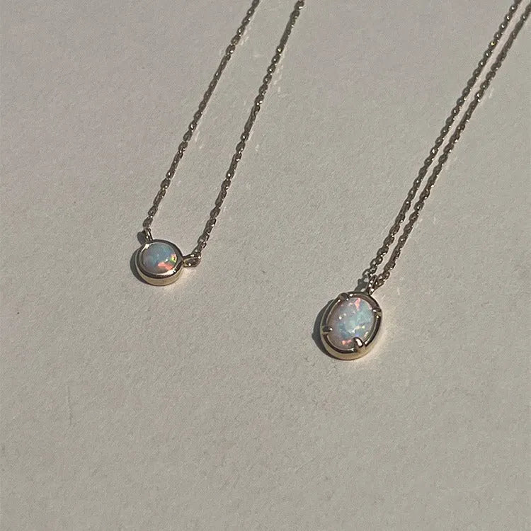Simple geometric oval pendant necklace in gold plating on a silver chain.