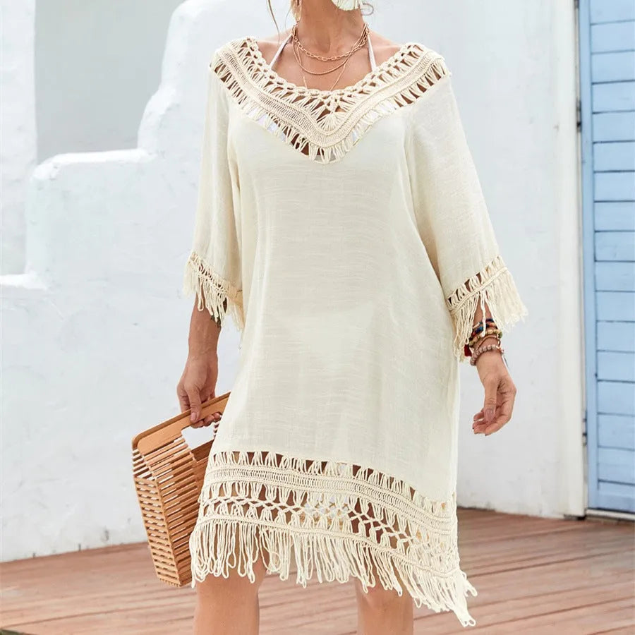 Apricot crocheted patchwork beach dress on a hanger showing textured knit and mid-length skirt.