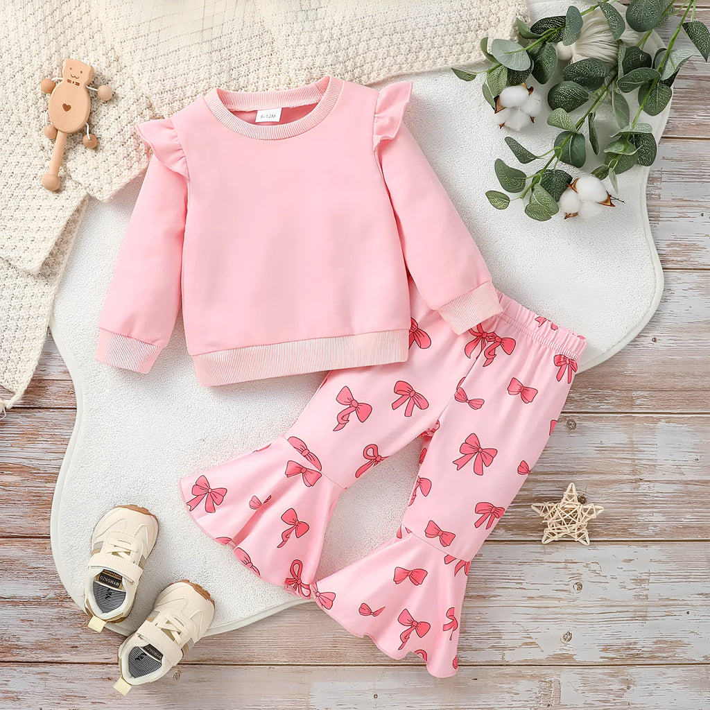 Pink two-piece girls' suit with long sleeve flounced sleeve knitted sweater, printed bow, and flared pants on white background