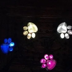 Four black paw print solar garden lights connected to central solar panel pole