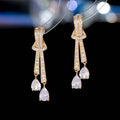 Knot drop earrings with silver needle post and zircon inlay in copper with electroplated finish, gold pearl colour