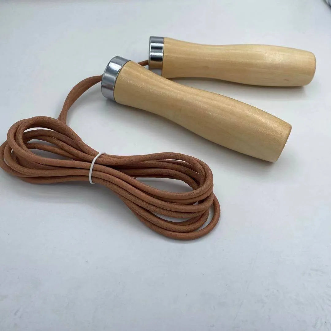 Real cowhide leather jump rope with solid wood handles and denim grip on grey background