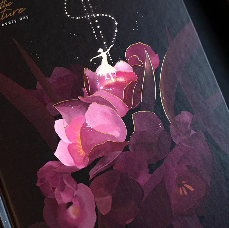 A5 notebook with luminous cover open to show colourful illustration pages, in Deep Blue, Gold, Light Blue, and Purple colour options.