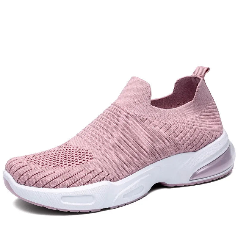 A pair of low-top slip-on sock shoes with a mesh upper and PVC sole on a plain background.