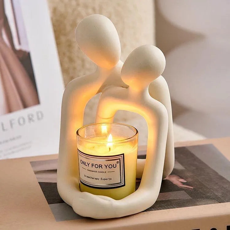 Modern minimalist loving couple resin statue in milky white or gold colour on a desk.