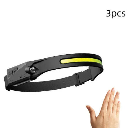 Black silicone USB rechargeable LED headlamp with side wave sensor, showing wide beam and long-range lighting.