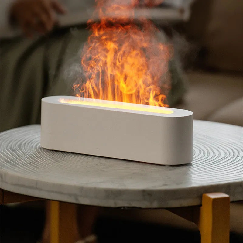 White square ultrasonic flame aroma diffuser and humidifier with LED light on a table.