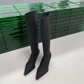 Women's black below the knee boots with pointed toe and stiletto heel, back zipper closure visible