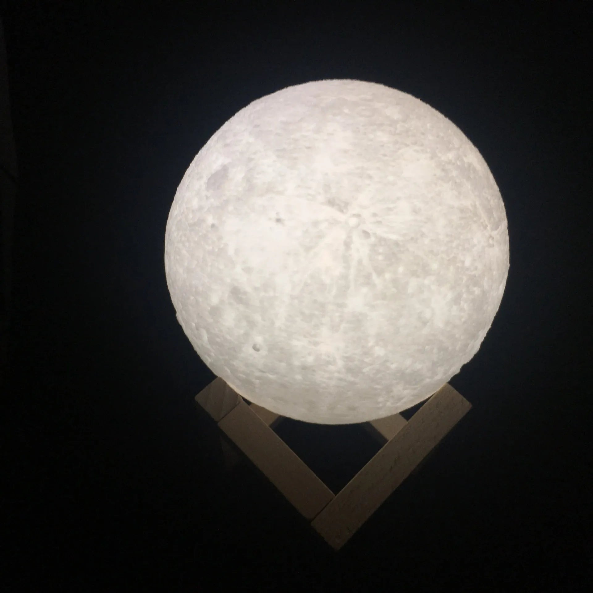 3D printed white moon lamp on wooden stand with touch-sensitive metal ring at base.