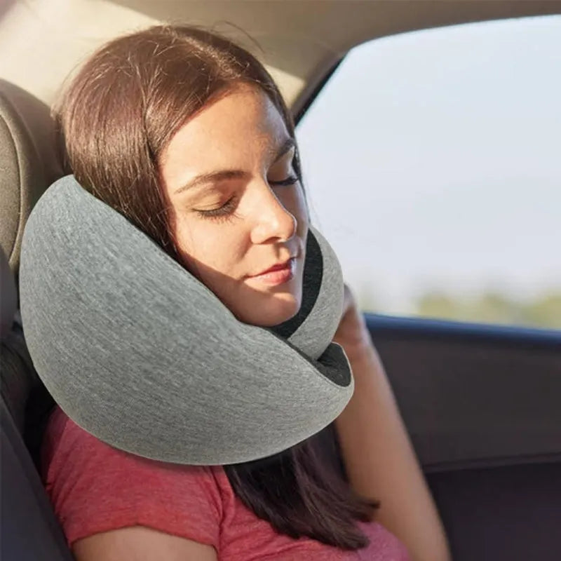 U-shaped memory foam travel neck pillow rolled up next to its carry bag, showing navy blue and grey colour options.