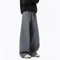 Men’s relaxed fit dark gray trousers with drawstring waist and belt on model
