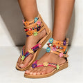 Beige ethnic Roman sandals with flat sole, round toe, and decorative beaded petals.