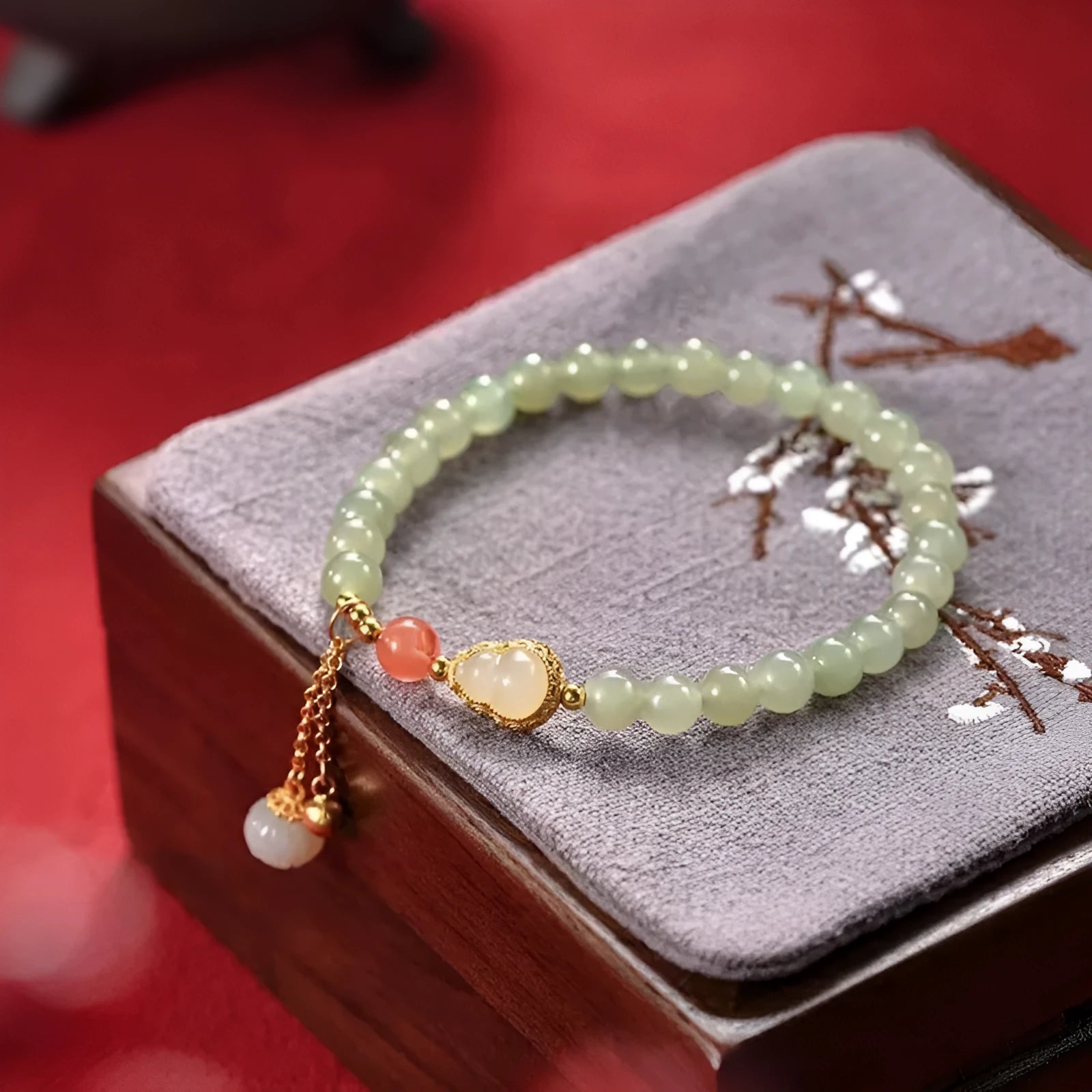 Women's jade bracelet with gold-plated gourd charm and Fu character pendant on a 6mm bead.