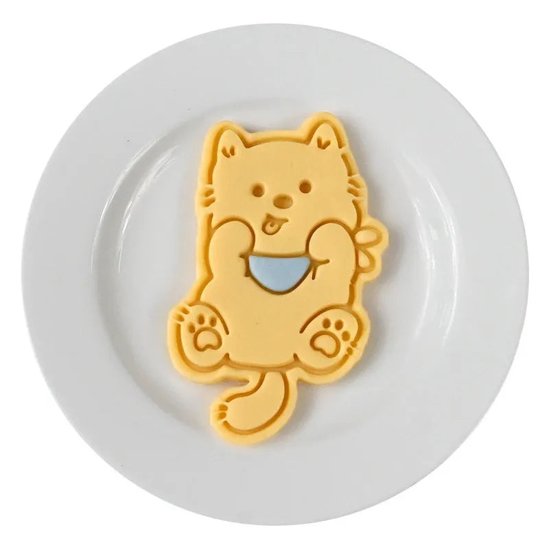 A 3D plastic biscuit mould showing raised puppy head, birthday hat, and dog cartoon designs.