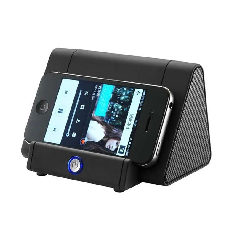 Small 5.5 cm round wireless Bluetooth speaker in black or white on a desk next to a mobile phone.