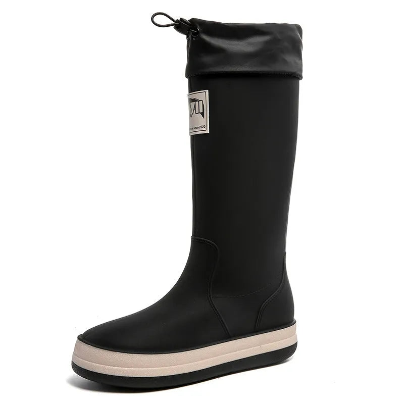 Pair of solid colour high tube PVC rain boots with a low heel on a non-slip sole.