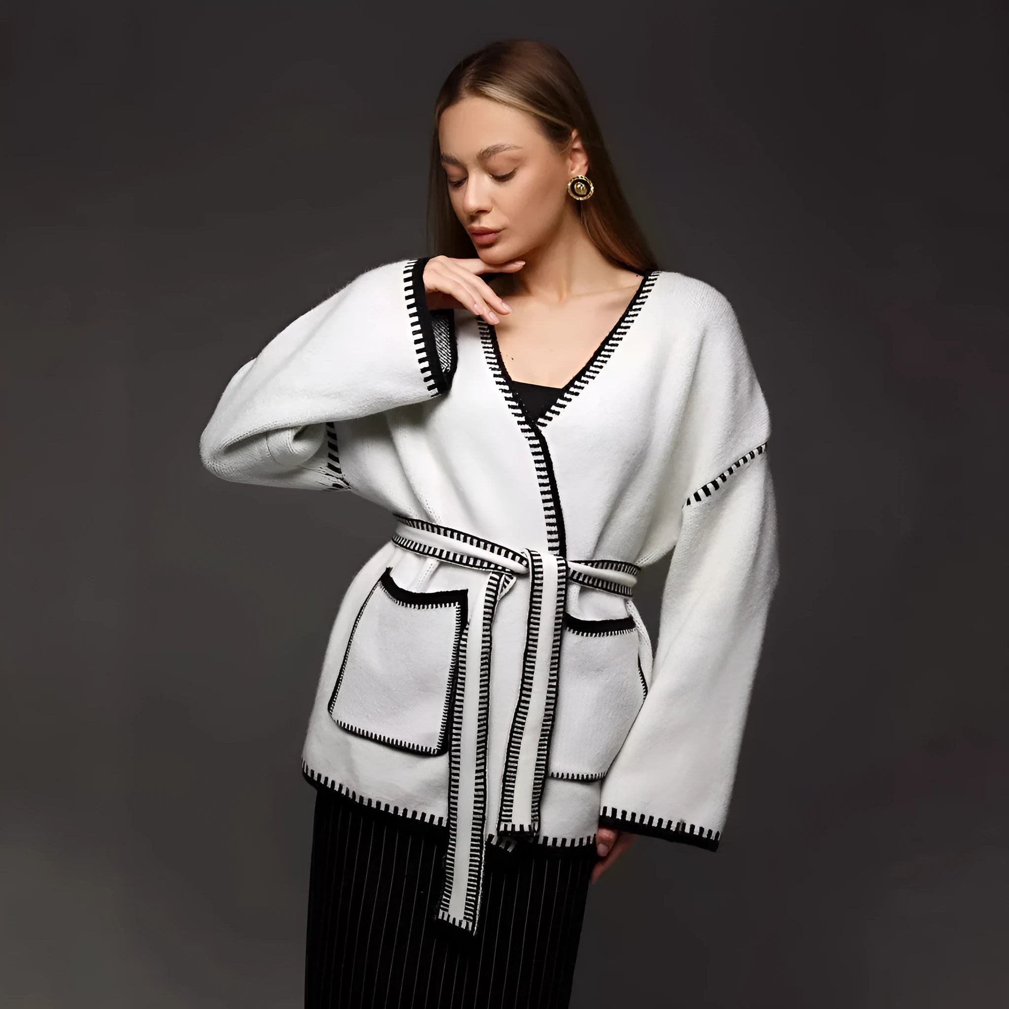 Loose black lace-up knitted cardigan sweater coat with long sleeves.