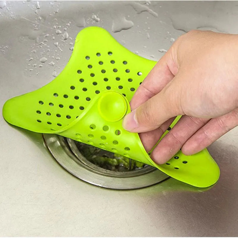 Three starfish-shaped TPR sink drain filters in blue, green, and white on a bathroom sink