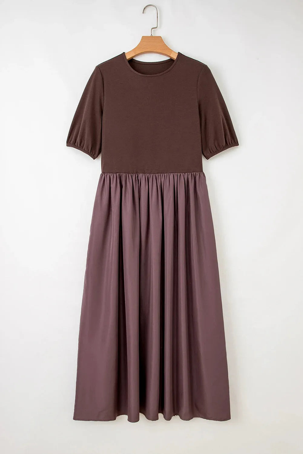 Woman wearing a coffee-coloured knitted patchwork dress with high waist and short sleeves