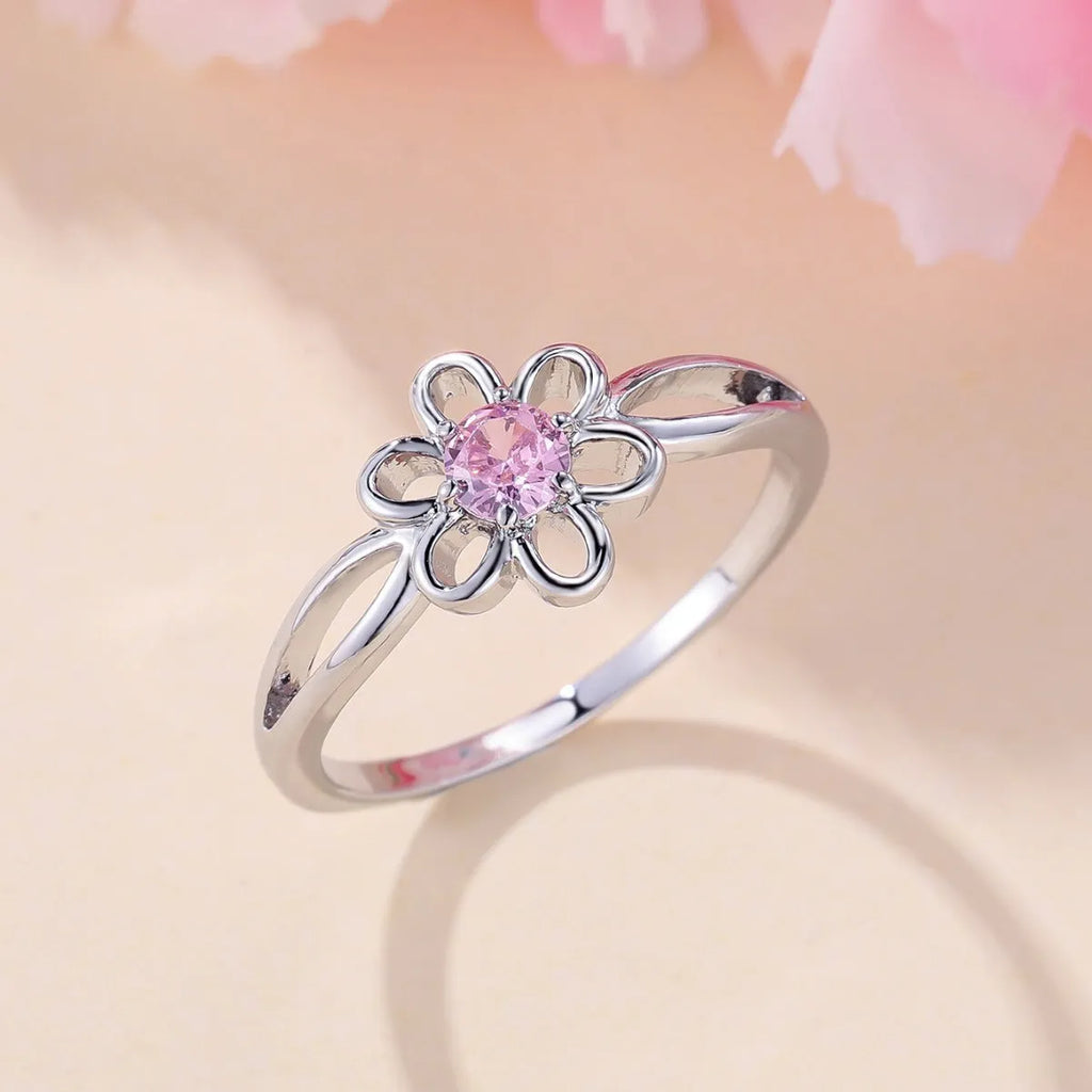 Women's hollowed flower fashion ring in electroplated platinum pink diamond colour on a white background.
