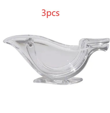 Clear acrylic bird-shaped manual lemon juicer on a kitchen counter