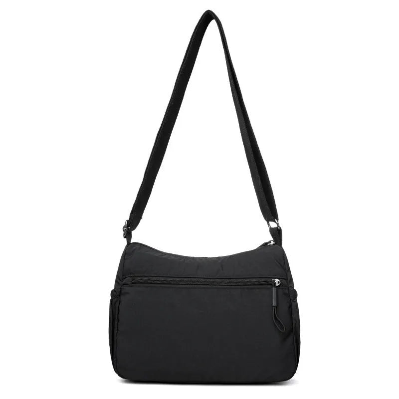 Grey water-repellent nylon crossbody bag showing outer pocket and internal organiser compartments.