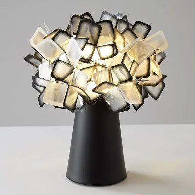 Nordic style decorative table lamp with metal base in a choice of colours on a bedside table.