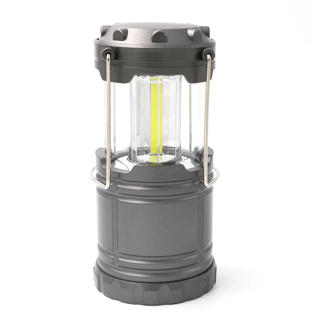 COB LED camping lantern in black, telescopic with hook, on outdoor background