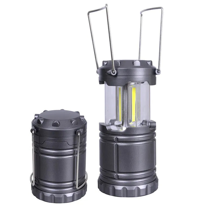 COB LED camping lantern in black, telescopic with hook, on outdoor background